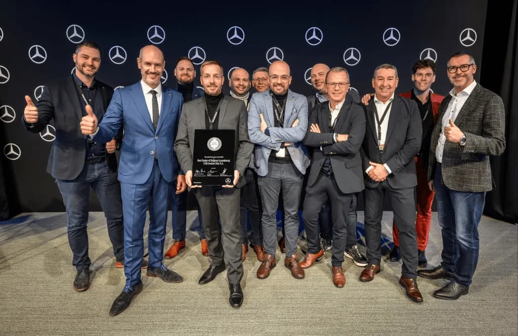 L’équipe de CAR Avenue Mercedes-Benz réunie pour une remise de trophée, devant un mur aux étoiles Mercedes-Benz