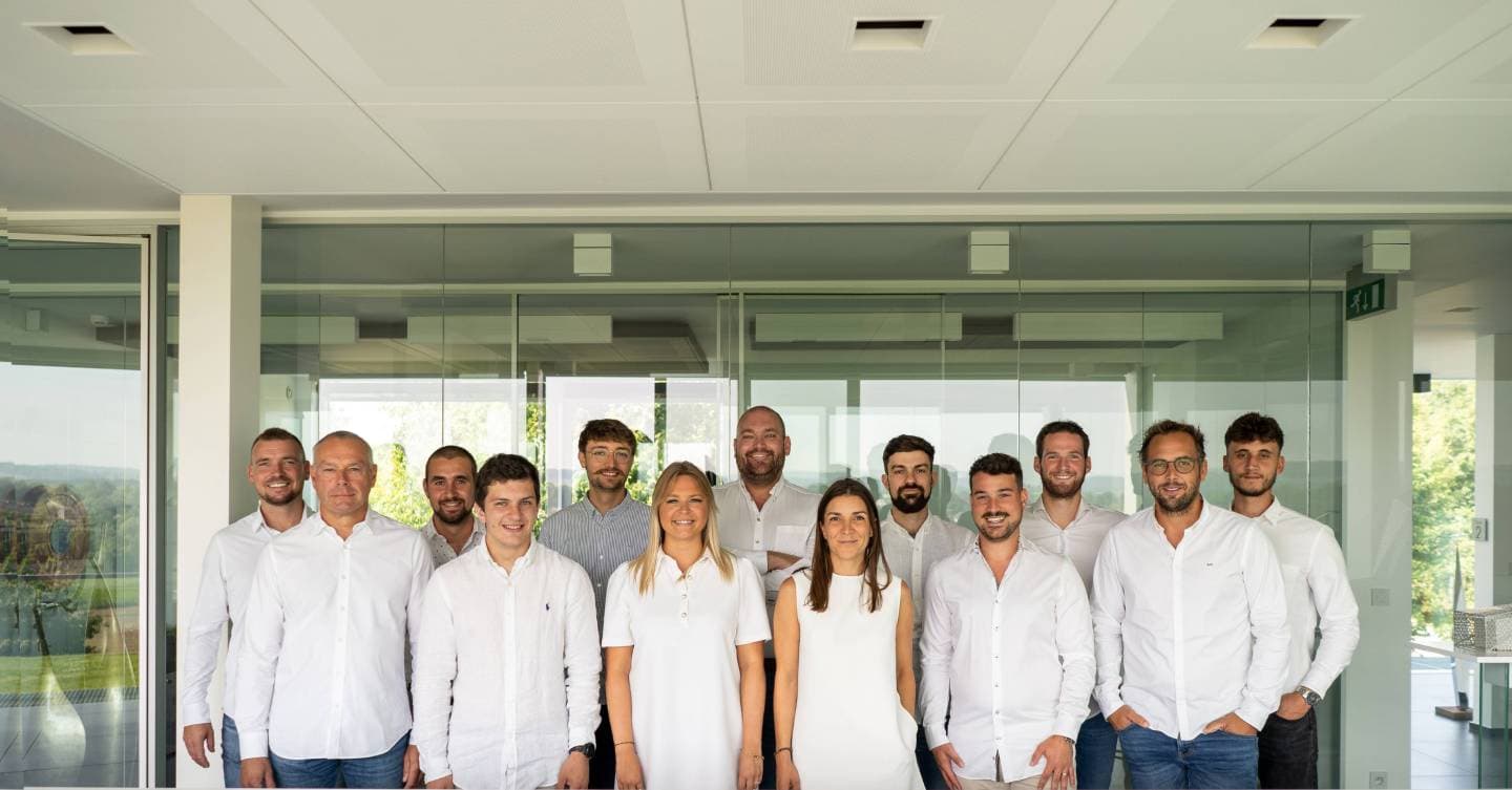 Une équipe en chemise blanche alignée dans un espace de bureau vitré