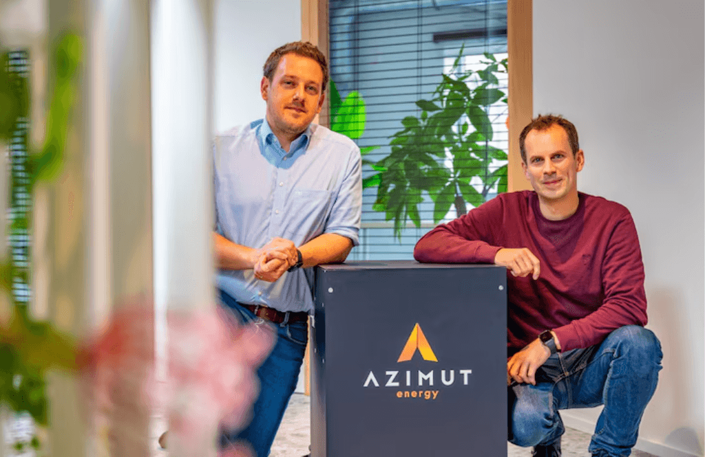 Deux membres d’Azimut Energy présentant le panneau de la marque dans leurs bureaux