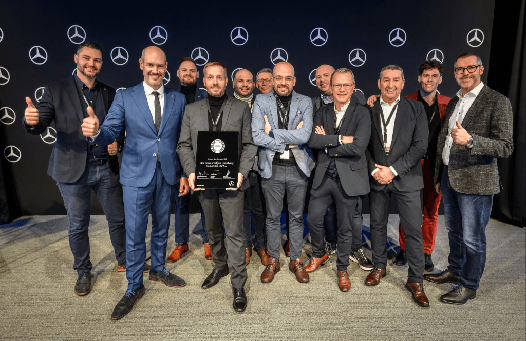 L’équipe de CAR Avenue Mercedes-Benz réunie pour une remise de trophée, devant un mur aux étoiles Mercedes-Benz